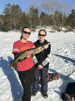 A DNR fisheries biologist and her daughter display a 28-inch northern pike they caught.