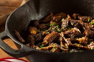 Morels cooking in a cast iron skillet