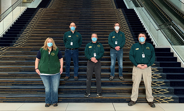 A DNR incident management team's members, with medical masks, pose for a photograph on a stairwell.