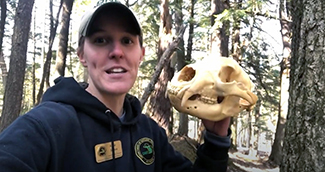 The Michigan DNR's Katie Urban is pictured holding an animal skull.