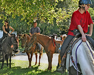 Three people riding horses