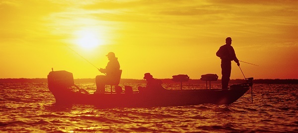 two people fishing from a boat, profiled in sun and shadow