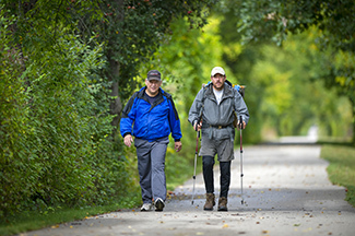 Two men hike toward the camera along the Iron Belle Trail in the Lower Peninsula.