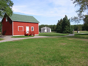 A red barn and a tarpaper barracks at the CCC Museum