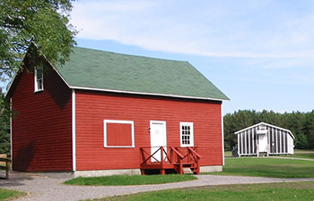 A red barn and a tarpaper barracks at the CCC Museum