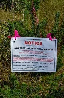 A notice alerts the public to a herbicide treatment.