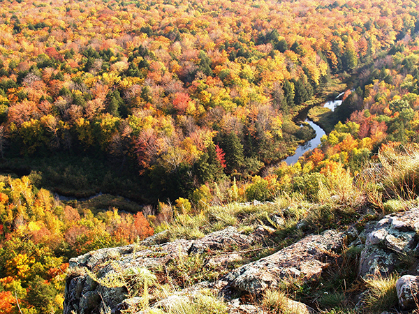 An autumn hilltop view of the Big Carp River at Porcupine Mountains Wilderness State Park is shown.