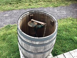 A fire pump concealed in a barrel at Fort Wilkins is shown.