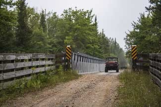 An off-road vehicle is shown crossing the bridge set to be replaced in Alger County.