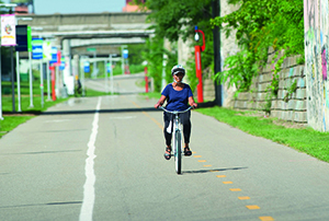 woman riding bike on Dequindre Trail 