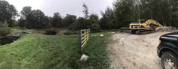 A DNR truck and construction equipment on site around the dam at Backus Creek State Game Area in Roscommon County, Michigan