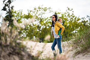 Mom and baby walking on a beachy trail
