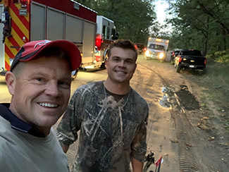 Michael and Brett Postema pictured with emergency vehicles Thursday.