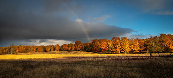 Rainbow over Pigeon River forest in fall