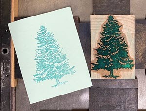A greeting card placed next to the white pine die it was printed from