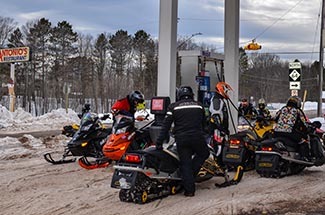 A group of snowmobilers gasses-up their machines at a service station in Ontonagon County.