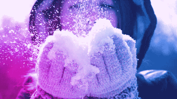 animated gif showing a smiling woman holding snow in her gloved hands and blowing snowflakes into the air