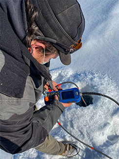 A DNR staffer measures the dissolved oxygen at an Upper Peninsula lake.