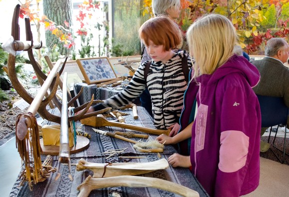 Two children look at a table of artifacts 