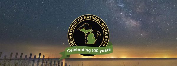 Banner image of DNR centennial logo against a starry sky