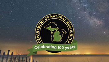 Michigan Department of Natural Resources 100 year logo against a starry sky