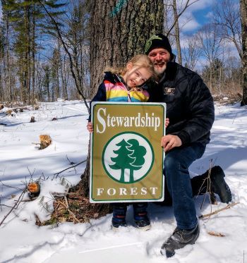 Phil Gignac and his granddaughter enjoy their woods. 