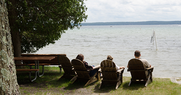 three people sitting in chairs on lakeshore at RAM Center
