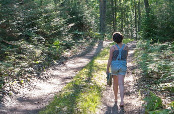 Girl walks on wooded trail at Cheboygan State Park