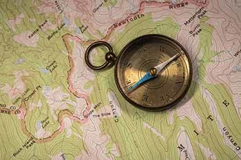 A compass sits atop a topographic map, two good tools to take to the woods.