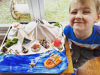 kid posing next to diorama