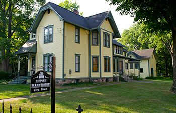 Mann House is a yellow Victorian with green trim.