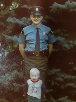 A family photo of Conservation Officer Averill and his young son is shown.