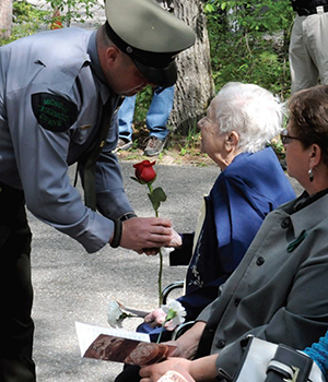 A conservation officer hands a rose to the widow of Gerald Welland in 2012.