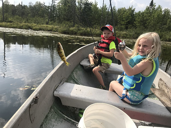 Two children fishing in a boat
