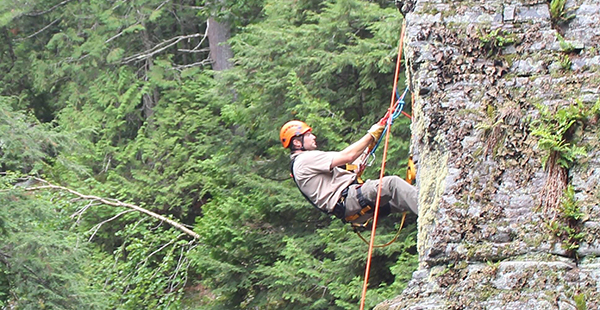 Park ranger climbs down cliff on rope