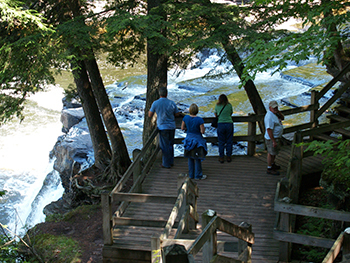 Park visitors take in the series of waterfalls along the Presque Isle River