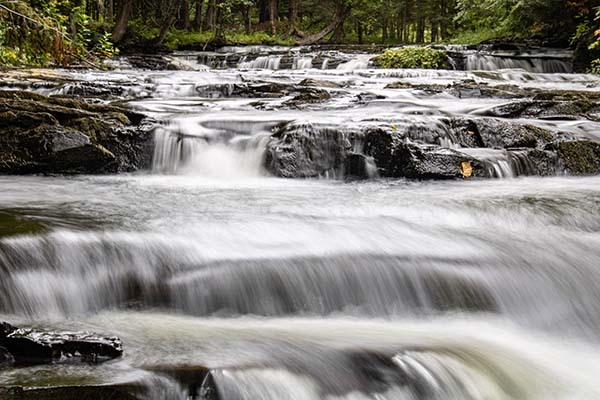 Cascading waterfalls are shown tumbling over rocks in Baraga County.