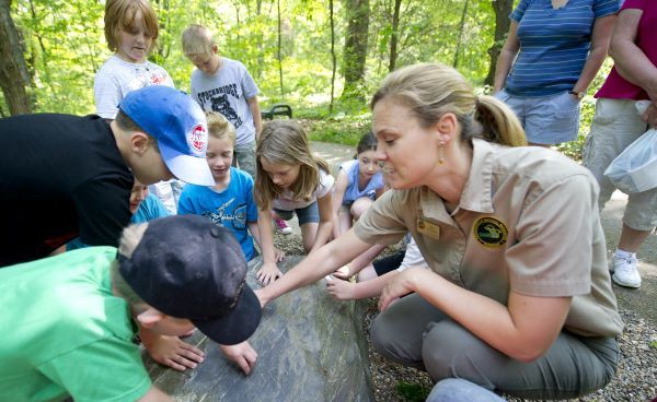 A DNR park interpreter teaches a group of kids about nature in an outdoors setting