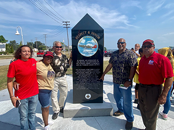 A group of people stands around the new Tuskegee Airmen memorial.