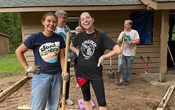 volunteers standing in front of worksite cabin