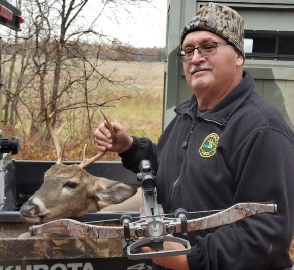 Wildlife technician, Vic Weigold, smiles and poses with a harvested deer.