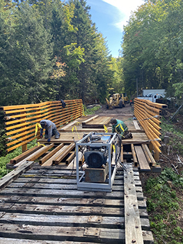 Workers are shown working on the decking of a bridge over the Little Carp River in Baraga County.