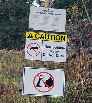 Signs posted at the water source in the Lake Mine area of Ontonagon County.
