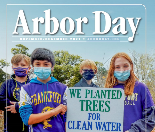 Cover of Arbor Day newsletter featuring students holding a sign: "We planted trees for clean water" 