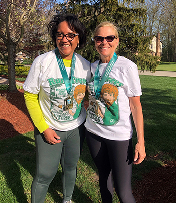 two participants wearing race T-shirts and medals
