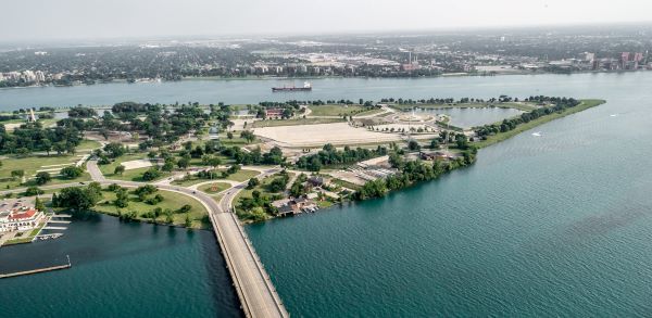 Aerial image of Belle Isle and Detroit River with blue waters and green trees 