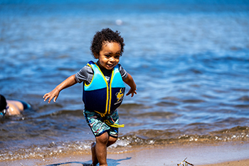 young boy in water at beach