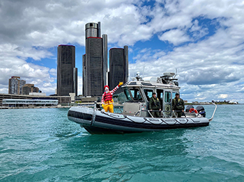 two conservation officers on patrol boat with Ronald McDonald