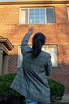 woman waving to friend in second-story window