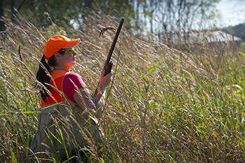 Female pheasant hunter in field